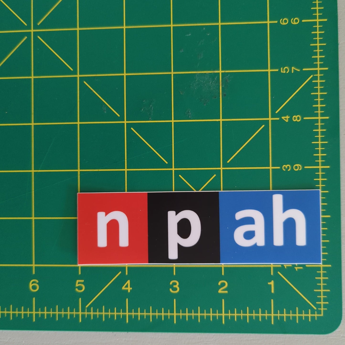 A red, black, and blue sticker in the style of the NPR logo that says "npah"