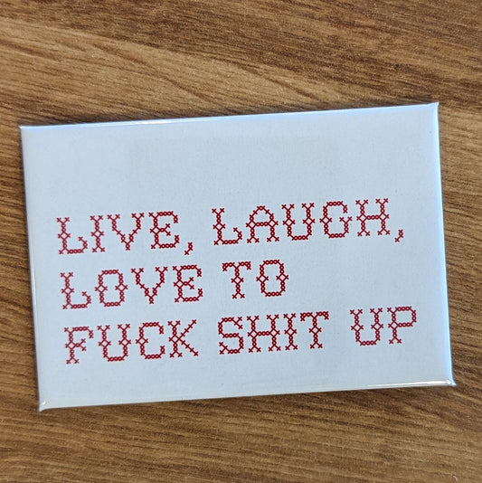 Rectangular white magnet that says "Live, Laugh, Love to Fuck Shit Up" in cross-stitch font
