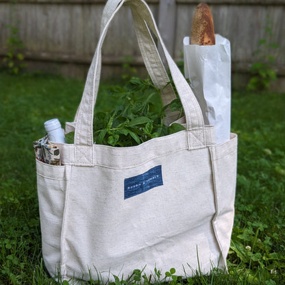 Canvas tote bag with exterior pockets, filled with food