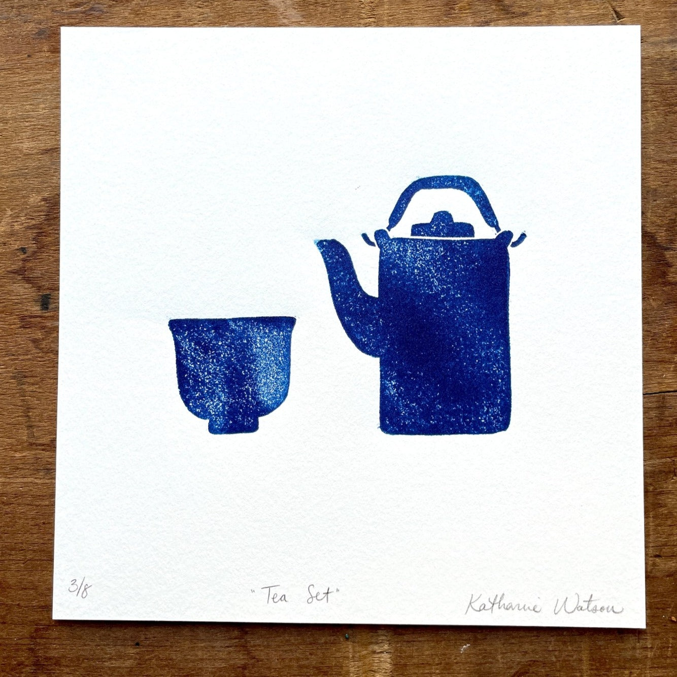 A block print of a teapot and cup in navy ink