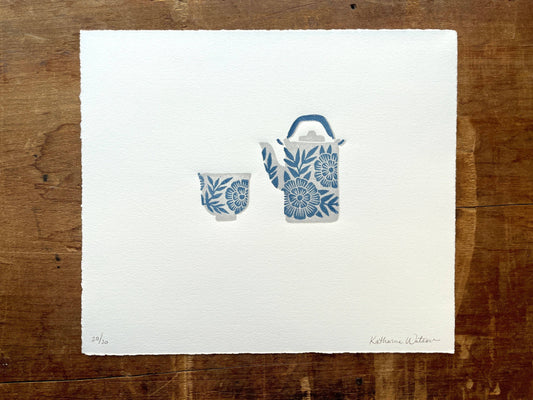 A reduction block print of a floral teapot and cup