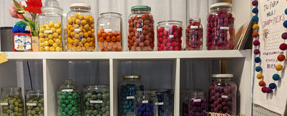 Photo of our wool felt bead collection arranged in glass jars by color